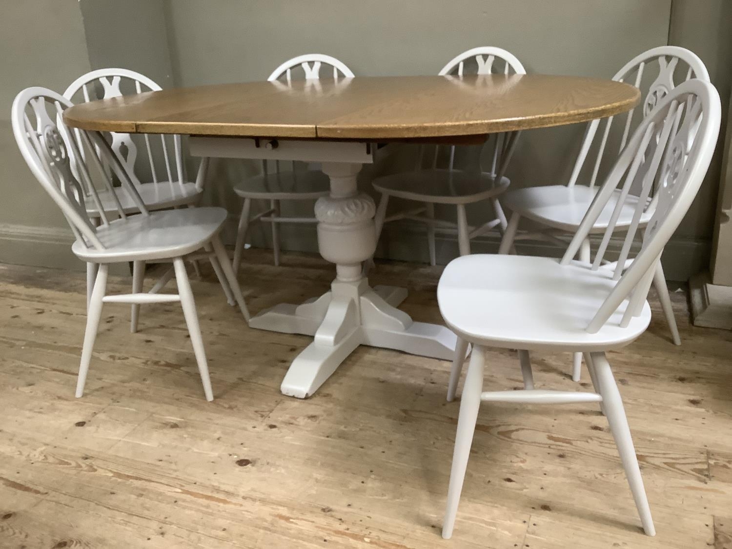 A painted and oak topped dining table with baluster supports and pull out folding leaf together with