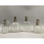 Four glass scent bottles, of varying heights and sizes, the glass bearing etched floral