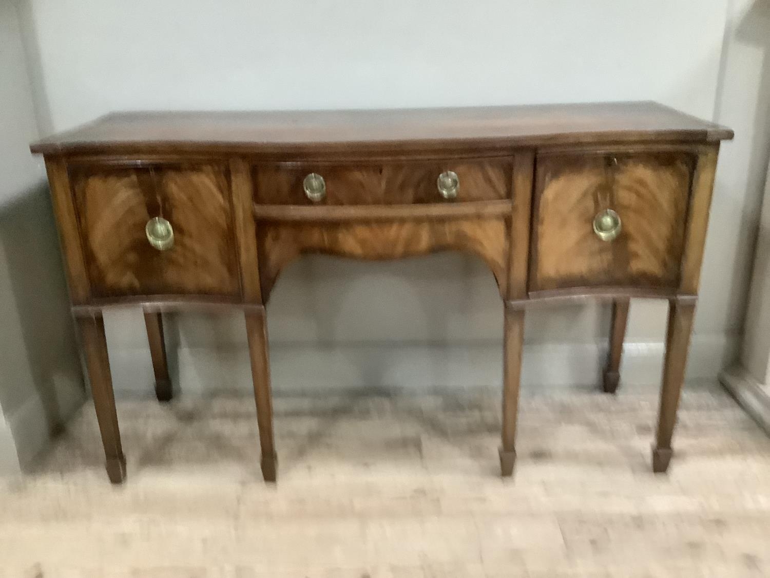 A reproduction mahogany serpentine sideboard with two long drawers flanked by two deep drawers