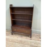 Reproduction bookcase with three shelves over one long drawer with brass handles, carved apron on