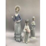 Three Lladro figurines including woman with parasol (at fault), girl with lilies and young boy