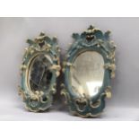 A pair of composite wall mirrors painted in blue and gilt, the frames formed of c-scrolls and