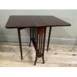An Edwardian mahogany drop leaf table with under tier, on brass casters