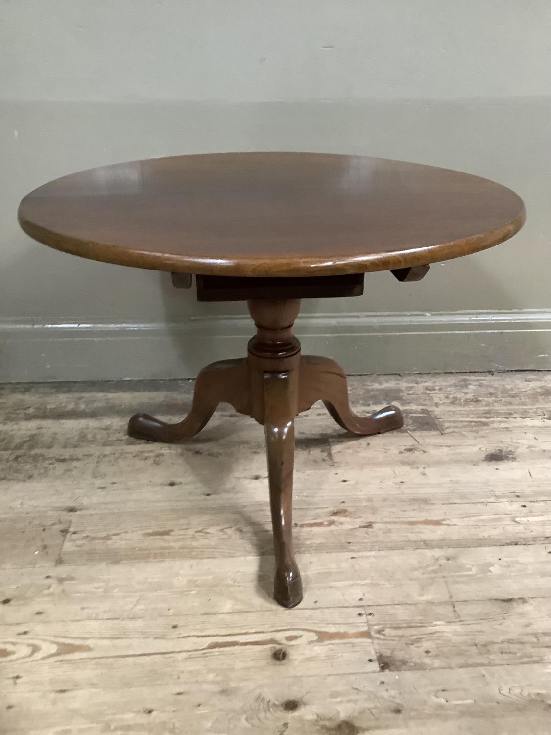 A mahogany circular tripod table, with turned support and on tripod base