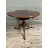 A mahogany circular tripod table, with turned support and on tripod base