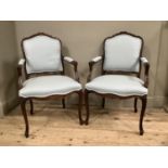 A reproduction mahogany French style carver chairs with cabriole legs and moulded cartouches to