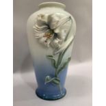 A Franz china vase of slightly tapering form, moulded in high relief with a lily against a pale blue