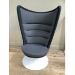 A mid century white acrylic swivel chair with large padded back in charcoal and grey upholstery on