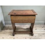 An oak school desk with double hinged lid transforming into writing slope with inkwell and pen