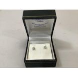 A pair of diamond stud earrings, both claw set with brilliant cut stones in 9ct white gold with base