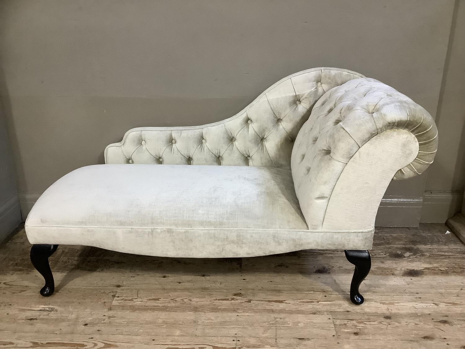 A reproduction button back miniature chaise lounge in champagne fabric on mahogany cabriole legs,