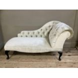 A reproduction button back miniature chaise lounge in champagne fabric on mahogany cabriole legs,