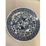 A Chinese blue and white charger in underglaze blue painted with two dragons amongst chrysanthemum