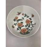 A reproduction famille rose bowl, overpainted with peonies and butterflies on white ground with