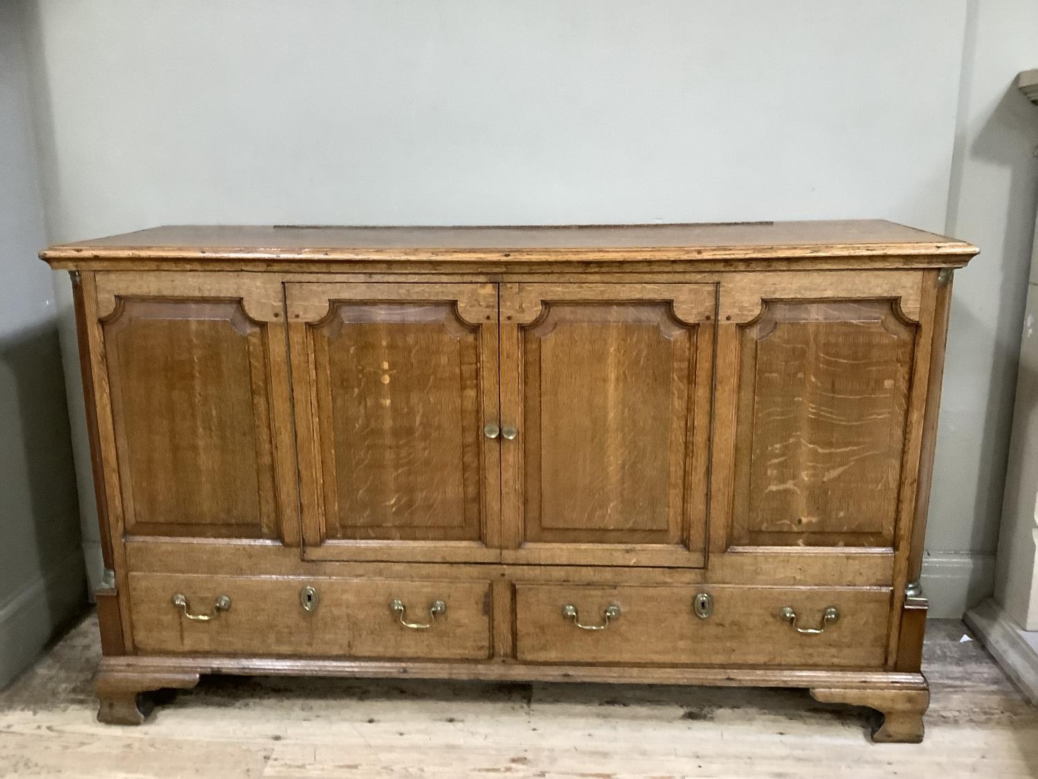 Victorian oak sideboard with two doors above two long draws with brass escutcheons and swan-necked