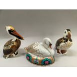 Three Royal Crown Derby paperweights comprising Swan, Puffin and a Pelican all with gold stoppers