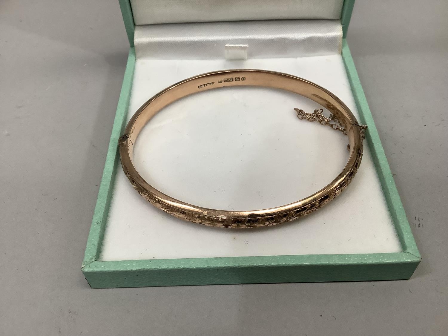 An Edward VII stiff hinged bangle in 9ct rose gold engraved to the front with thistles ,