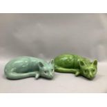 Two French porcelain figures of cats in repose, in green and blue raku glazes