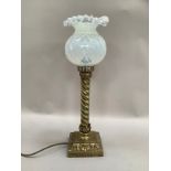 A brass Victorian style table lamp having a leaf capped wrythern column on a leaf cast base of