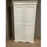 A white painted double wardrobe with internal hanging space, carved base and pediment top, 106cm