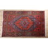 A MIDDLE EASTERN RUG, the mid blue field with a deep coral stepped lozenge, filled with geometric