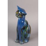 A C H BRANNUM 'BARUM' EARTHENWARE SITTING CAT, glazed in mid blue, green, brown and pale blue,