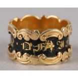 A WILLIAM IV MOURNING RING in 18ct gold, 'in memory of' in gold gothic letters raised against a