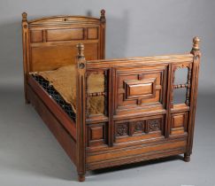 AN EDWARD VII WALNUT SINGLE BEDSTEAD, with ebonised detailing, the curved profile headboard triple