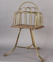 AN EDWARDIAN BRASS AND MAHOGANY FOUR DIVISION REVOLVING MAGAZINE RACK with splayed legs on ball feet