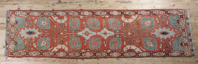 A MIDDLE EASTERN RUNNER of coral ground with opposing lotus and medallion pattern in turquoise and