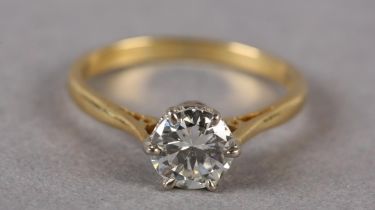 A SINGLE STONE DIAMOND RING in 18ct yellow and white gold, the brilliant cut stone crown set flanked