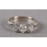 A THREE STONE DIAMOND RING, the graduated brilliant cut stones each in a four claw setting in a