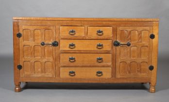 SCHOOL OF THOMPSON OF KILBURN AN ADZED OAK SIDEBOARD having two short and three long drawers flanked