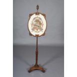 A LATE REGENCY ROSEWOOD POLE SCREEN, with oval banner in moulded and scrolled frame, the pole with