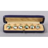 A SET OF SIX VICTORIAN DRESS STUDS, each collet set with a circular cabochon green and iridescent
