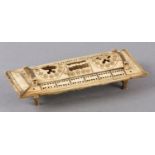 AN EARLY 19TH CENTURY FRENCH PRISONER-OF-WAR BONE GAMES CASKET pierced hinged cover and sliding
