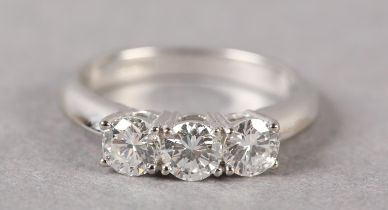 A THREE STONE DIAMOND RING in 18ct white gold, the brilliant cut stones claw set in line,