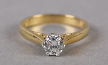 A SINGLE STONE DIAMOND RING in 18ct yellow and white gold, the brilliant cut stone crown set,
