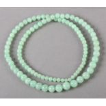 A JADE NECKLACE OF GRADUATED SPHERICAL BEADS, without fastener and strung on a later line,