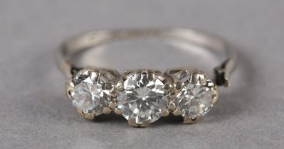 A THREE STONE DIAMOND RING in platinum, c1960, the graduated brilliant cut stones claw set in