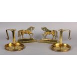 A PAIR OF ARTS AND CRAFTS BRASS CHAMBERSTICKS, with strap work handle, wide circular dished base,