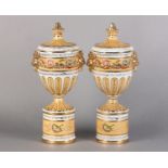 A PAIR OF PEDESTAL VASES AND COVERS of urn form, fluted covers with knopped finials above twin