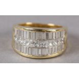 A DIAMOND SET RING in 18ct gold, the graduated baguette and princess cut stones pave set flanked