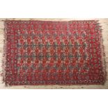 A MIDDLE EASTERN RUG, the flatweave field of camel colour with thin red stripe, filled with ten rows