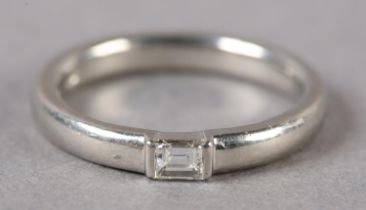 A SINGLE STONE DIAMOND RING in platinum channel set with a baguette cut stone, approximate weight of
