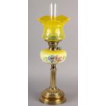 A VICTORIAN BRASS REEDED COLUMN OIL LAMP, the tinted yellow glass reservoir painted with flowers, on