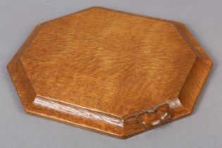 A THOMPSON OF KILBURN 'MOUSEMAN' OAK BREAD OR CHEESE BOARD, of irregular octagonal form, the