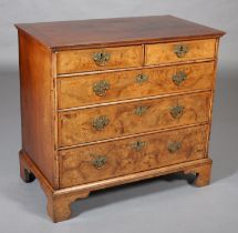 AN 18TH CENTURY FIGURED WALNUT CHEST OF DRAWERS, the top quarter veneered and crossbanded with