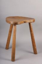 A THOMPSON OF KILBURN 'MOUSEMAN' OAK THREE-LEGGED STOOL, having a kidney-shaped saddle seat carved