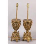 A PAIR OF LATE VICTORIAN GILT METAL TABLE LAMPS, the pierced basket body having four panels cast